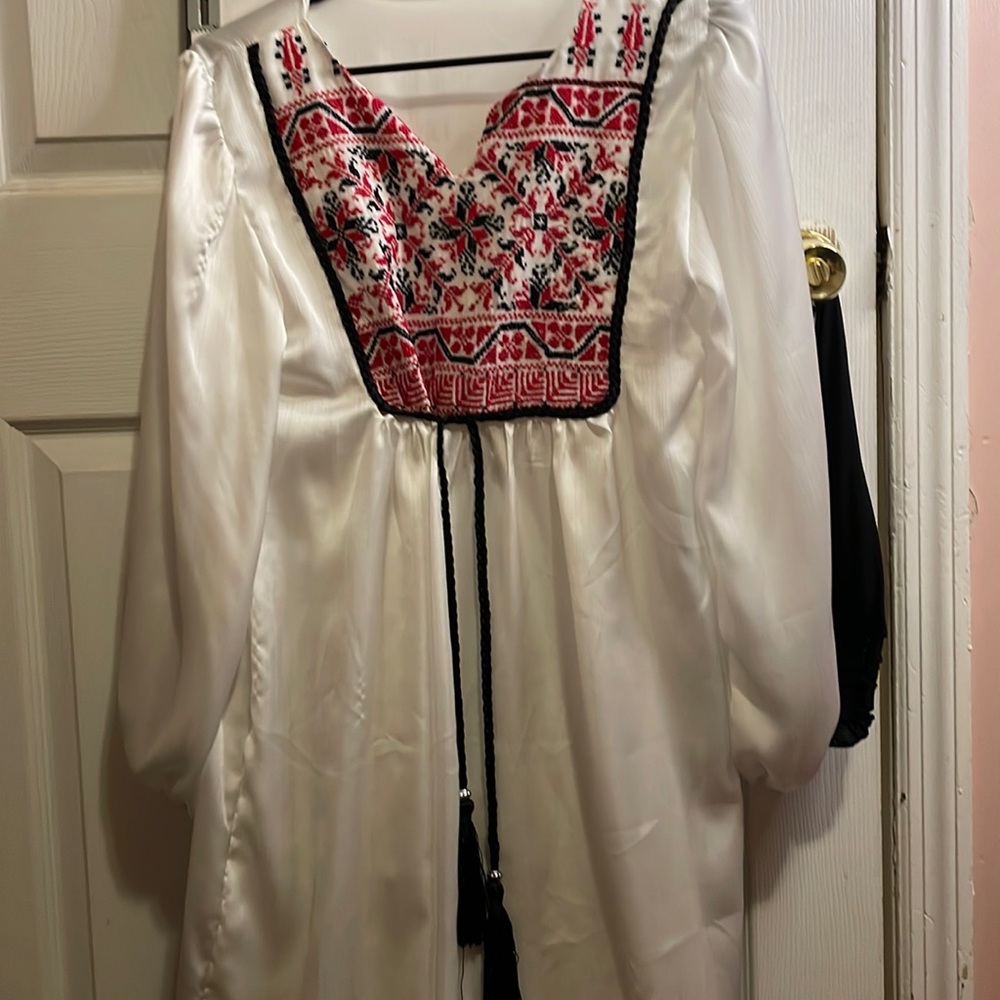 White blouse hand sewn cross-stitch embroidery. Traditional Palestinian Tatreez.